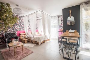 第戎Romantisme et glamour 2 avec spa , clim et jardin的卧室配有一张床和一张桌子及椅子
