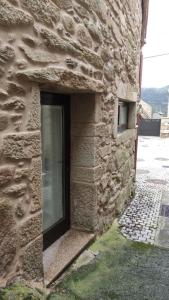 穆罗斯Casa de Canteiro Louro - Muros的石头建筑一侧的窗户