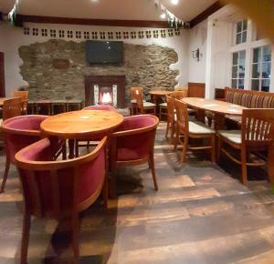 兰盖夫尼布尔酒店的餐厅设有木桌、椅子和壁炉