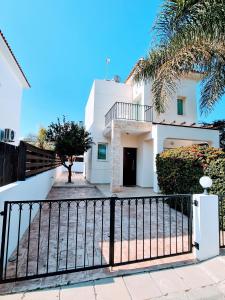 帕拉利米尼Villa Alkioni 31的一座白色的房子,有门和棕榈树