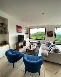 雅科Vista Lapas Nativa Resort的客厅配有沙发和2把蓝色椅子