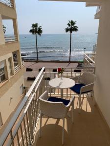 卡拉米洛阿尔波拉达公寓的一个带桌椅和海滩的阳台