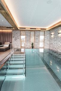卡普伦ZAGLGUT Hotel-Chalet-Wellness - Summercard Zell am See-Kaprun included的一座房子里一个带玻璃地板的游泳池