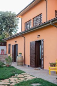 奥贝里塞Agriturismo I Grappoli的橙色的房子,设有棕色的门和黄色的长凳