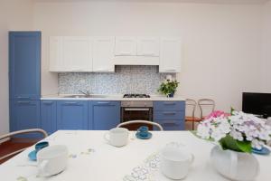 圣特奥多罗Villetta La Conchiglia Man的厨房配有蓝色橱柜和鲜花桌