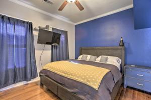 加尔维斯敦Cozy Beach Bungalow Near Galveston Seawall and Pier的一间卧室设有一张床、一台电视和蓝色的墙壁