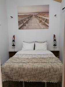 科武港Chalé da Baía的卧室配有一张床,墙上挂有绘画作品