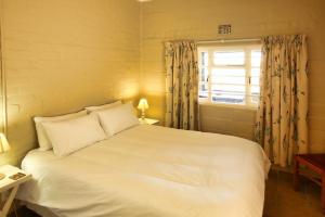 兰格班Oppi Stuppi Langebaan的卧室设有一张白色大床和一扇窗户。