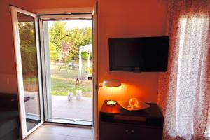 美西尼Phivos Home & Garden的一间带电视和滑动玻璃门的客厅