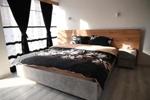 斯科普里Villa Castella的一间卧室配有一张大床和木制床头板