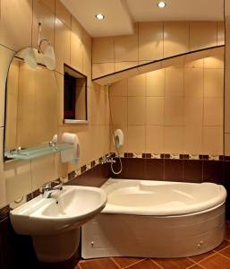 莫姆奇尔格勒Hotel Berito的浴室配有盥洗盆、卫生间和浴缸。