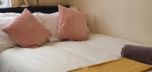 ParksideCoventry City House的床上配有粉色和白色枕头的床