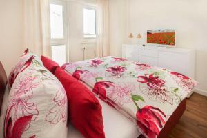 萨斯尼茨Penthouse Saphir mit Meerblick的一间卧室配有红色和白色床单