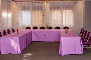 坎帕拉Das Berliner Hotel的一间设有两张桌子和椅子的房间,配有紫色的桌布