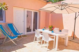 费拉约港Appartamenti Mare Portoferraio的庭院配有桌椅和遮阳伞。