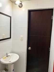 卡利Hotel Bisou的浴室配有盥洗盆和带镜子的淋浴