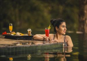 VaduvanchalChembarathi Wayanad Boutique Resort的坐在水里喝一杯的女人