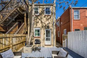 巴尔的摩Trendy Spot in Downtown Baltimore/Fellspoint的一个带椅子和围栏的庭院和一座房子
