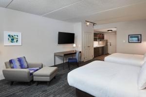 汉密尔顿TownePlace Suites by Marriott Hamilton的酒店客房配有一张床、一把椅子和一张书桌