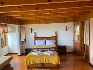 库埃察兰德尔普罗格雷索Posada Quetzalin的一间卧室设有一张床和木制天花板
