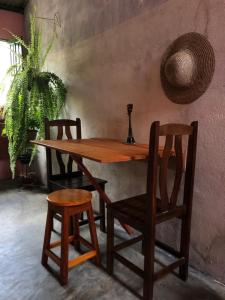 穆库热Casa di Vó的一张木桌和两把椅子,一张桌子和一株植物