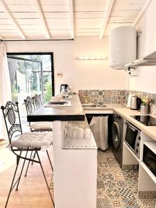 尼姆CASA AZUL - jardin, calme, tennis的厨房配有柜台和椅子