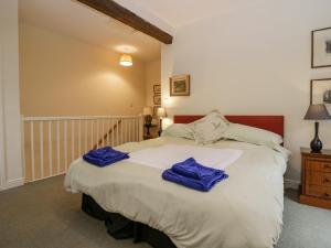 卡特梅尔Longlands Groom's Quarters的一间卧室配有一张带蓝色毛巾的床