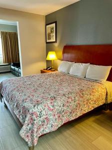 孟菲斯American Way Inn & Suites的一间卧室配有一张带花卉床罩的大床
