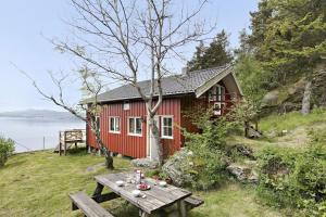斯塔万格House by the sea - 3 bedrooms and possibility to rent a boat的一间红色的房子,前面设有一张野餐桌