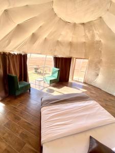 瓦迪拉姆Rum Kingdom Camp的帐篷内的卧室,配有一张床和两把椅子
