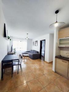 圣巴尔托洛梅Acogedor apartamento Besos de Elah的厨房以及带桌子和沙发的客厅。