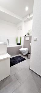 巴登-巴登New Modern SelfCheckin PublicFreeParking HighSpeed Wifi KingSizeBed的白色的浴室设有浴缸和水槽。