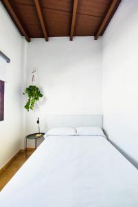圣巴尔托洛梅Acogedor apartamento Besos de Elah的配有木制天花板的客房内的白色床