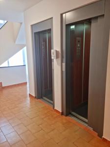 马塔拉斯卡尼亚斯Paraíso!的走廊上设有两扇电梯门,铺有瓷砖地板