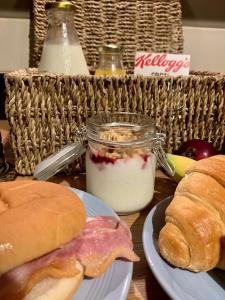 佩恩顿Bella Vista的一张桌子,上面放着三明治和一罐酸奶和面包