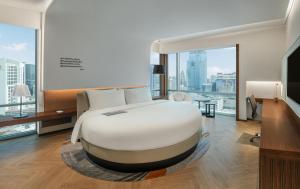 曼谷Le Meridien Bangkok的卧室设有一张白色大床和大窗户