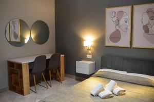 科林斯瓦西利奥斯马里诺斯旅馆的一间卧室配有一张床、一张书桌和镜子