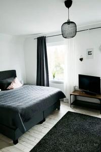 策勒Modernes Apartment mit Balkon free Parking Netflix的一间卧室配有一张床、一台电视和一个窗口