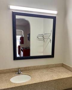 孟菲斯American Way Inn & Suites的浴室内水槽上方的镜子