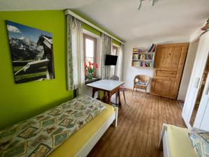 巴特科尔格鲁布Im- Oberland - Berg - KönigsCard的一间卧室设有绿色的墙壁、一张床和一张桌子