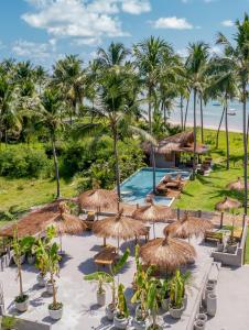 佩德拉斯港Zai Patacho的一个带游泳池、草伞和棕榈树的度假村