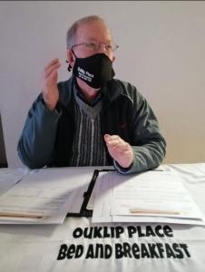 鲁德普特Ouklip Place Hotels的坐在桌子上的人,脸上戴着面具