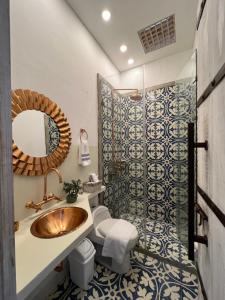 卡利MAHI CASA BOUTIQUE的一间带水槽、卫生间和镜子的浴室