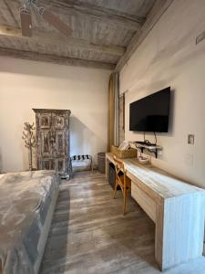 卡利MAHI CASA BOUTIQUE的卧室配有一张床,墙上配有电视。