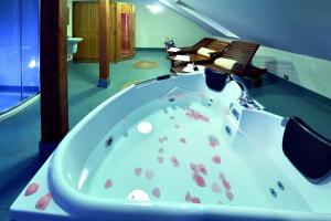 韦尔卡鲁穆尼卡Penzión Víchrica的浴室设有大浴缸,内有岩石