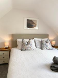 兰鲁斯特Modern 4-bed Cottage Llanwrst Town Centre & Parking - Snowdonia! near Betws-y-Coed的卧室配有带枕头的白色床