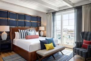 纽波特海滩丽都楼傲途格精选酒店的一间卧室配有一张大床和一把椅子