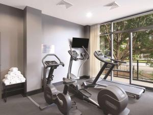 悉尼悉尼机场阿迪纳公寓式酒店的健身房设有两辆健身自行车和窗户