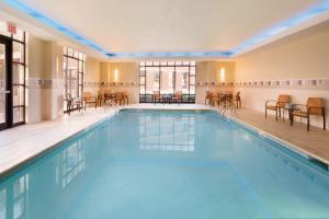 俄克拉何马城俄克拉何马城万怡酒店的大楼内一个带桌椅的游泳池