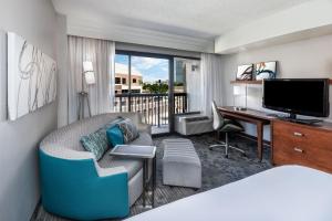 俄克拉何马城俄克拉何马城万怡酒店的酒店客房配有一张床、一张书桌和一台电视。